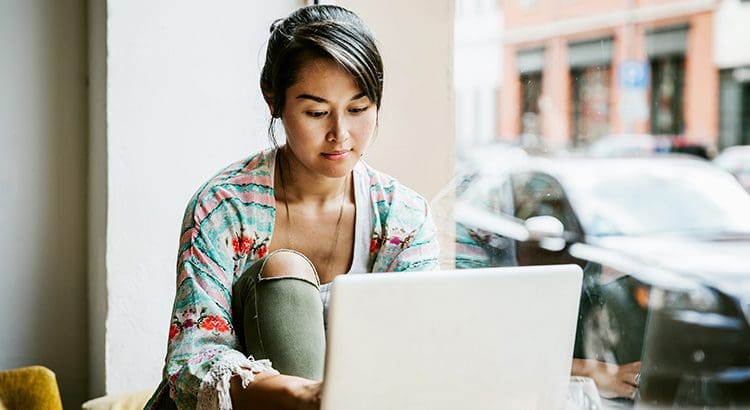A woman sitting in front of a laptop computer.