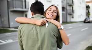 A woman is hugging a man with keys in her arms.