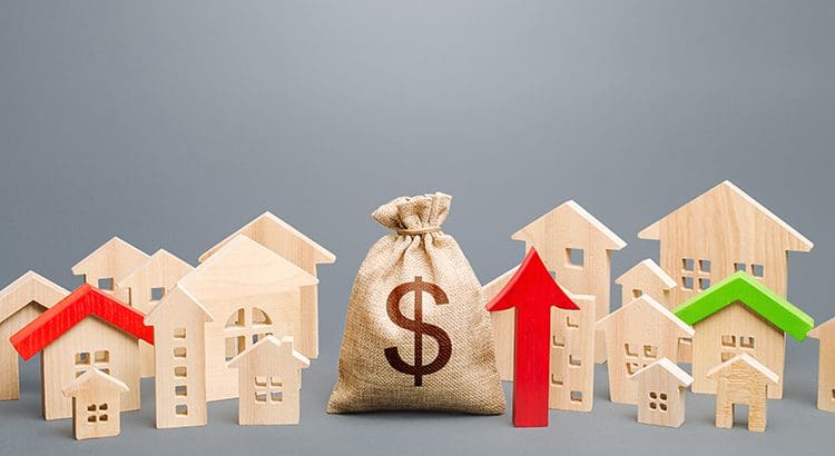 A bag of money sitting in front of some houses.