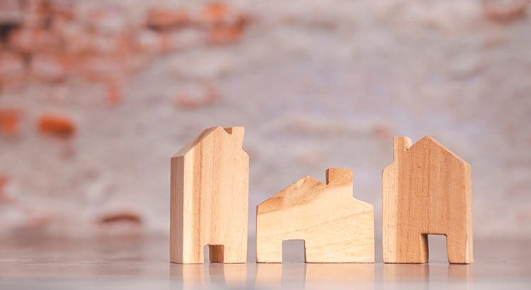 A wooden model of a house on top of a table.