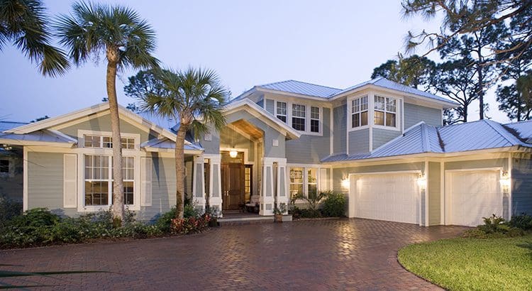 A large home with palm trees in the front yard.