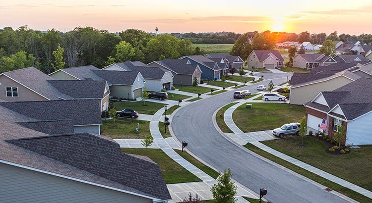 A view of houses and cars in the evening.