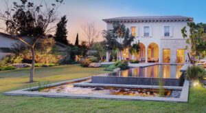 A large white house with a pool in the middle of it.