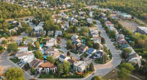 A view of houses from above, with trees in the background.