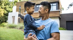 A man holding his son in the arms of him.