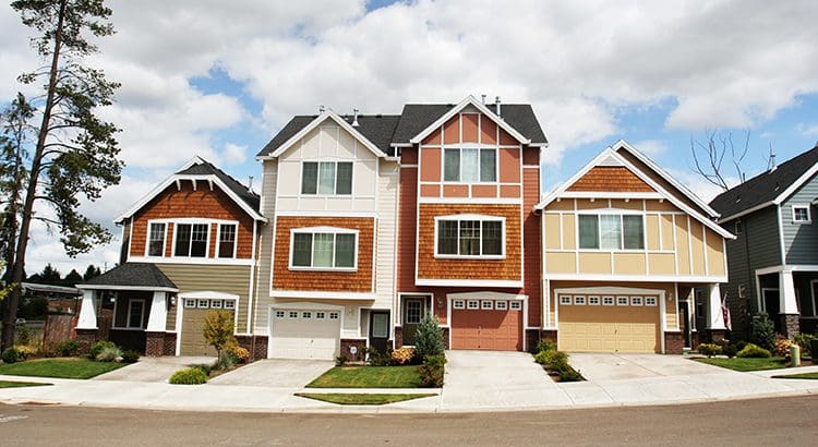 A row of houses with garage doors on the side.
