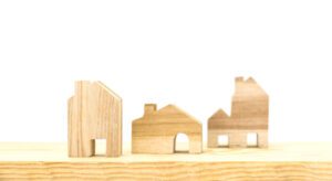 A wooden model of houses on top of a shelf.