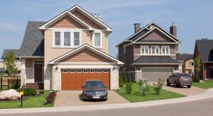 A car parked in front of two houses.