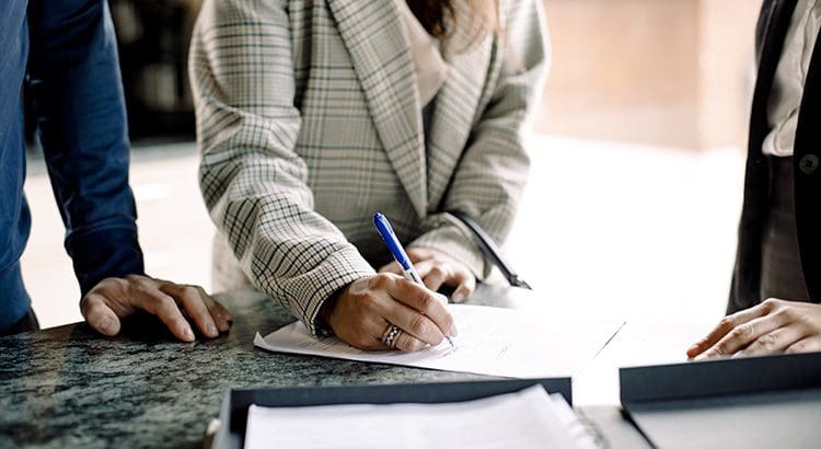 A person writing on paper with pen and ink.