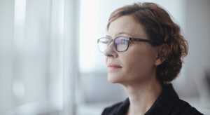 A woman with glasses looking up at something