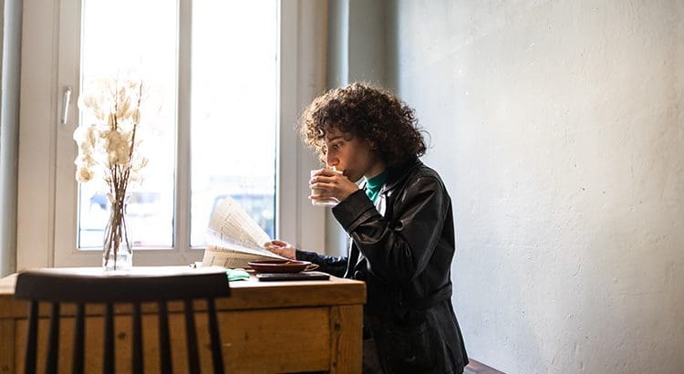 A woman sitting at a table with her laptop.