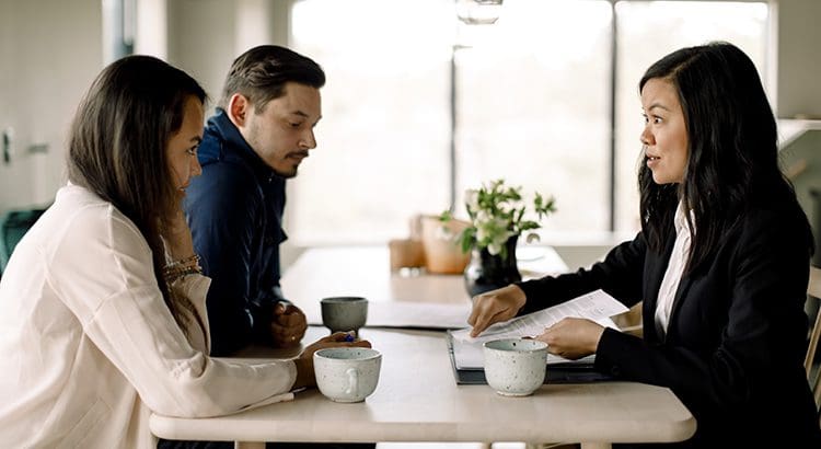 A man sitting at a table with two other people.
