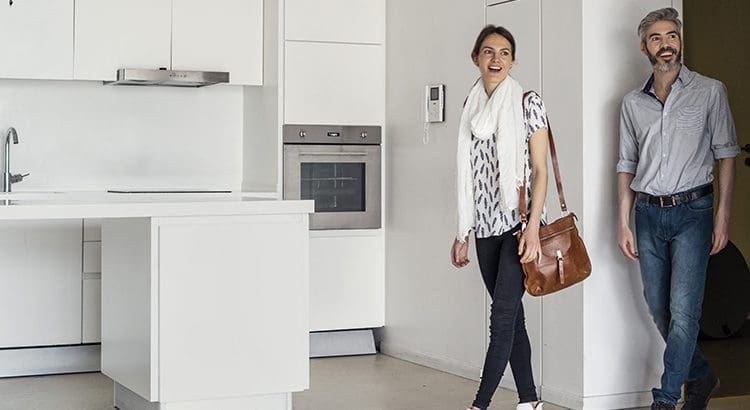 A woman walking in the kitchen with her purse