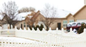 A white fence in front of a house.