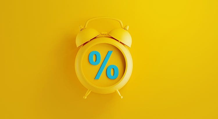 A yellow alarm clock with the word " percent " on it.
