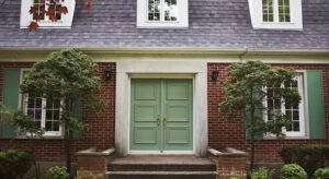 A green door is in front of the house.