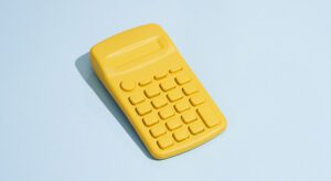 A yellow calculator is sitting on the floor.