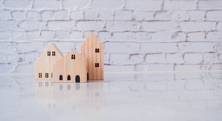 A wooden model of houses sitting on top of a table.