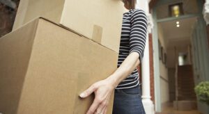 A woman holding onto boxes while moving.