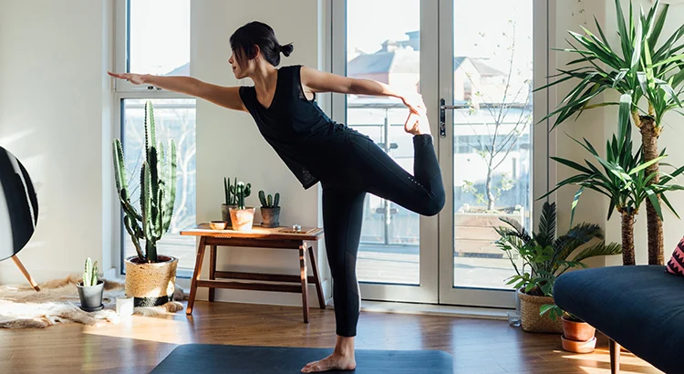 A woman is doing yoga in her living room.