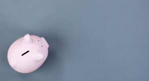 A pink piggy bank sitting on top of a blue table.