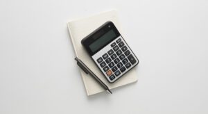A calculator sitting on top of a notebook.