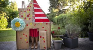 A cardboard house with red and yellow decorations.
