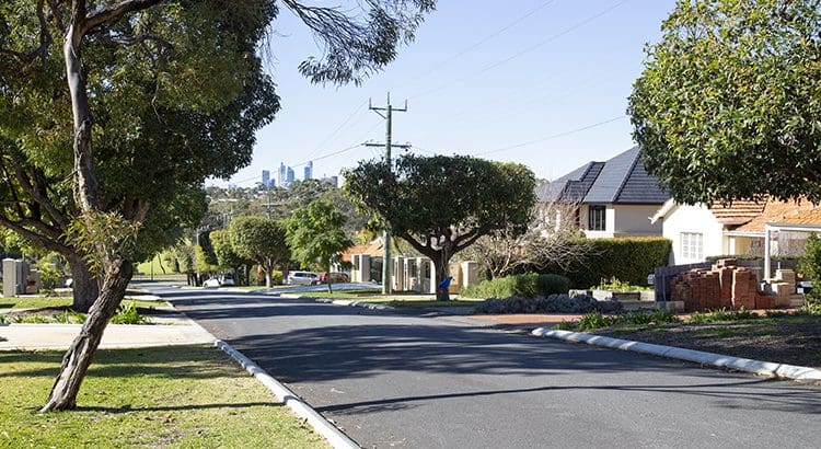 A street with houses and trees on the side.