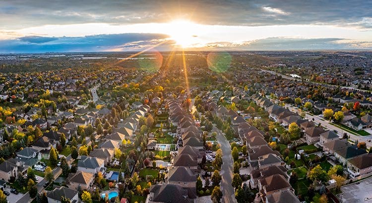A view of the sun setting over a neighborhood.