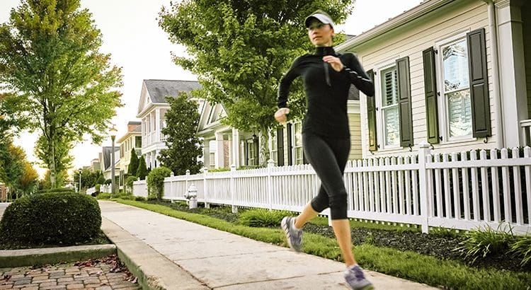 A woman running down the street in her black outfit.