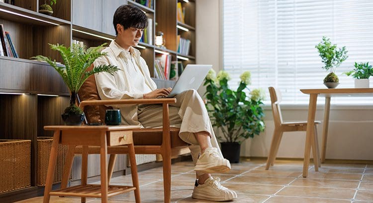 A man sitting in front of a laptop computer.
