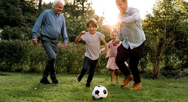 A group of people playing soccer in the grass.