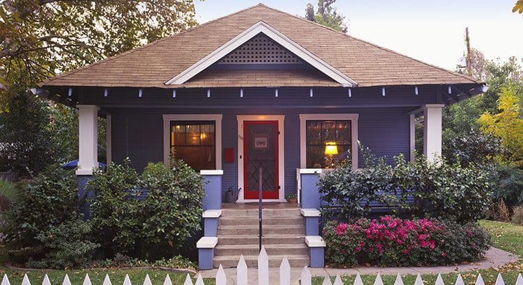 A house with a red door and white picket fence.