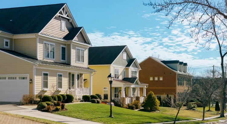 A row of houses with trees in the background.