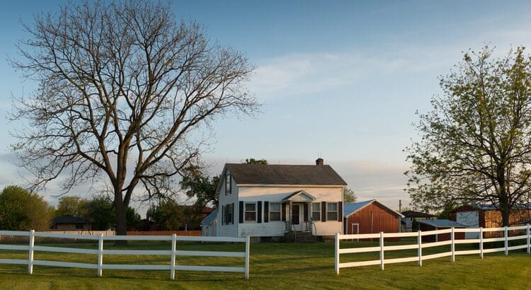 A white house sitting in the middle of a field.