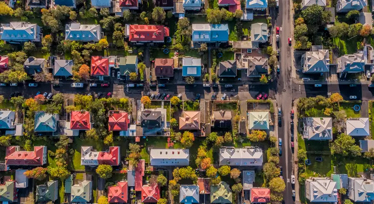A bird 's eye view of many houses on the side of a road.