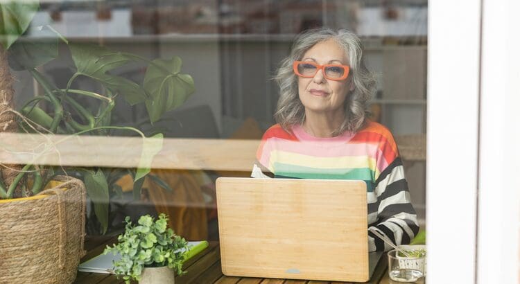 A woman sitting at a table with her laptop.