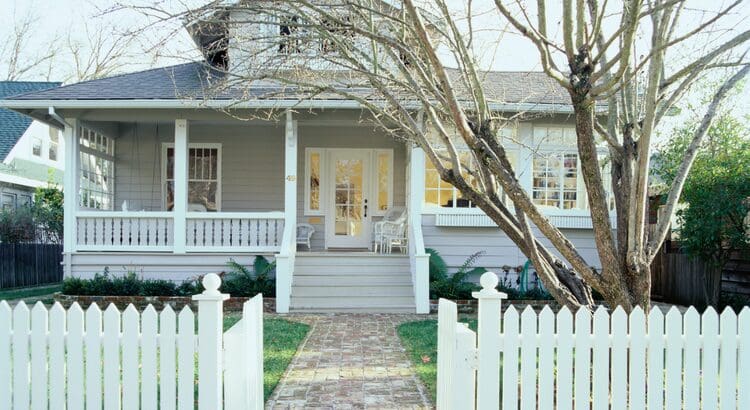 A white picket fence is in front of the house.