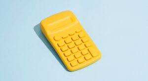 A yellow calculator sitting on top of a table.