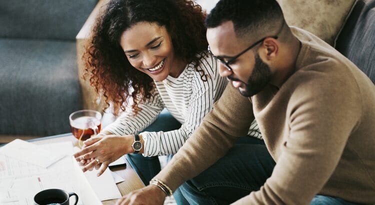 Two people laughing while looking at a laptop.