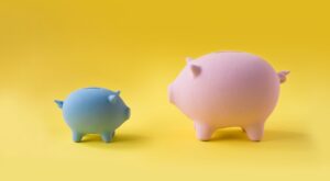 Blue and pink piggy banks on yellow background.