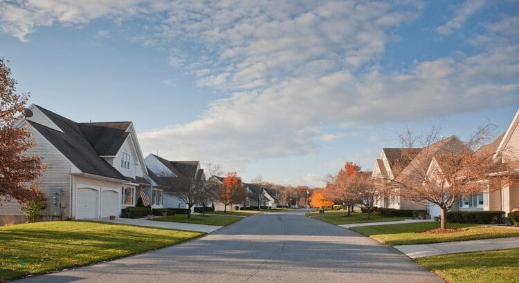 Suburban street with houses and autumn trees.