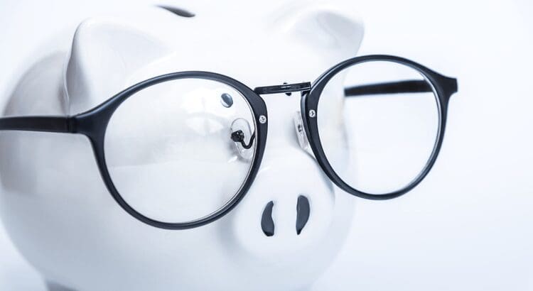 Piggy bank wearing black-rimmed glasses.
