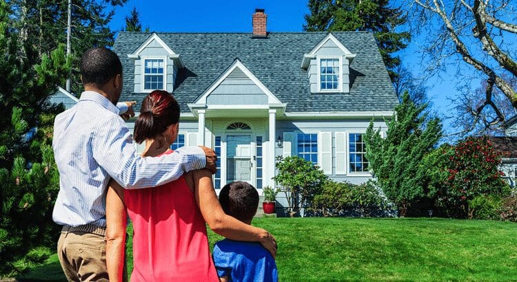 Family admiring their new home together outside.