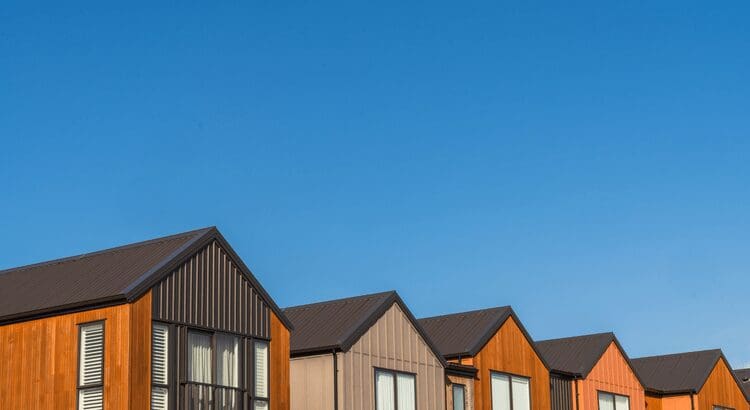 Row of colorful modern houses under blue sky.