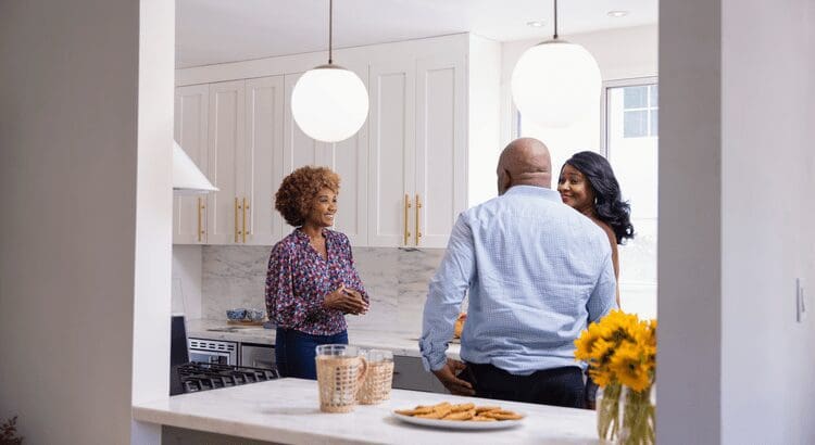 People talking in a modern kitchen.