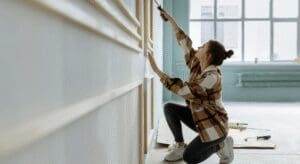 Person painting wall in bright room.