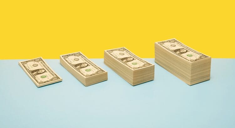 Stacks of dollar bills on colorful background.