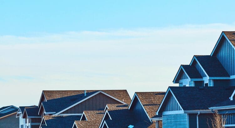 Rooftops of suburban houses under clear sky.