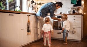 Father baking with two children in kitchen.